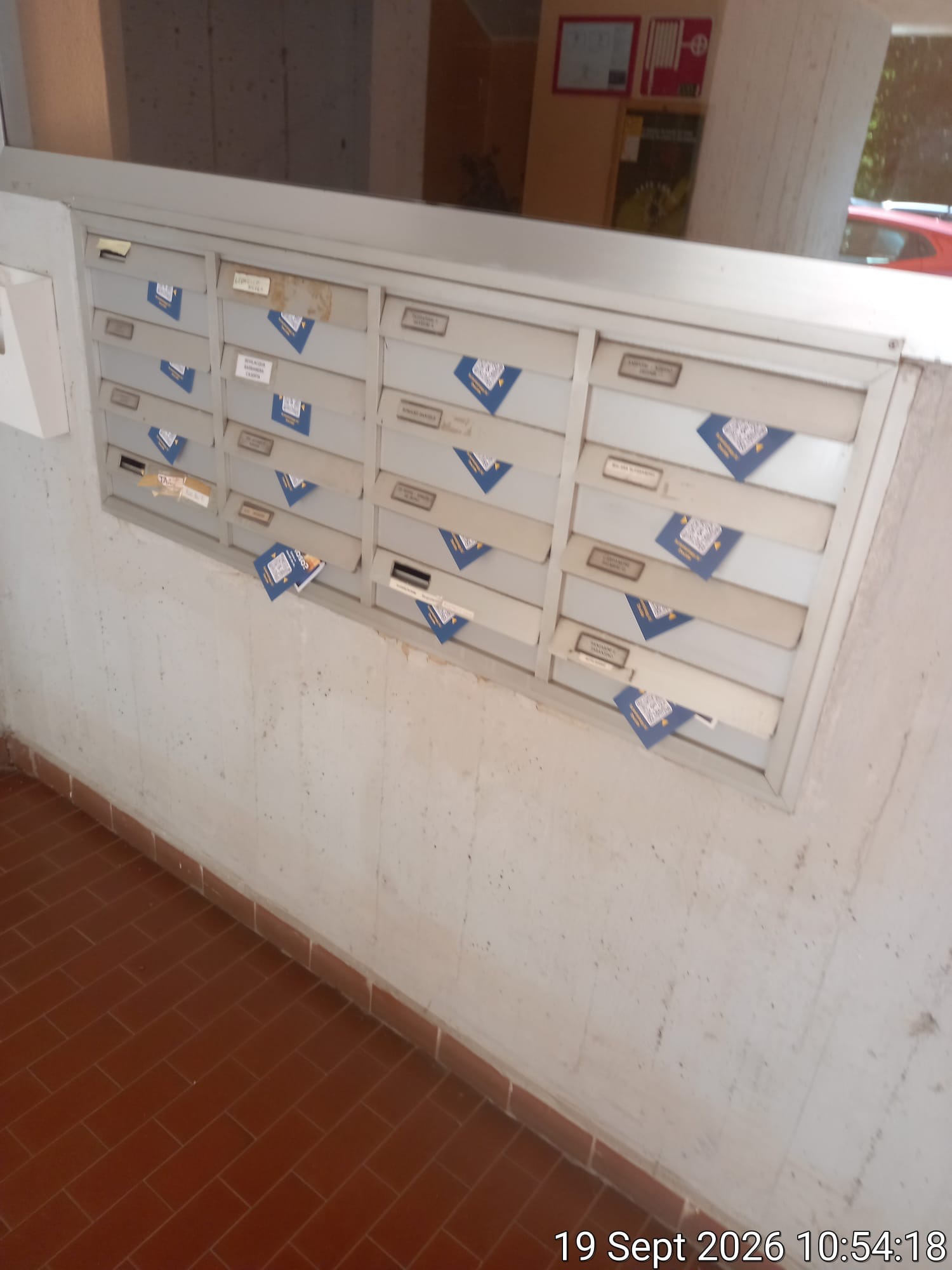 Volantini inseriti nelle cassette postali di un condominio durante una distribuzione porta a porta — Intermedia